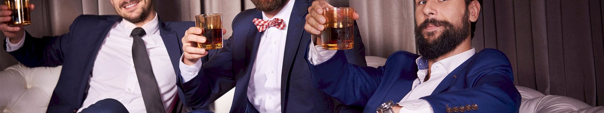 Three men enjoying a glass of whiskey of a stag weekend.
