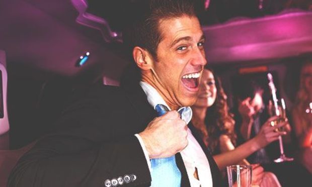 Man inside party bus smiling and having fun with group of friends