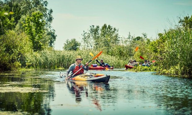 Men cruising down a river in their kayaks