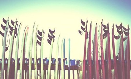 Red and white surfboards standing up. Explore Newquay Stag Party ideas below: