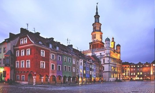 Buildings lit up at sunset in Poznan. Discover Poznan Stag Party ideas below: